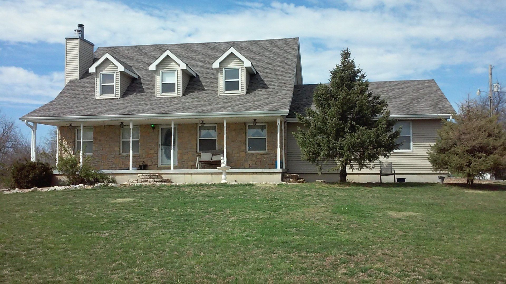A brick house with a gray roof and white trim