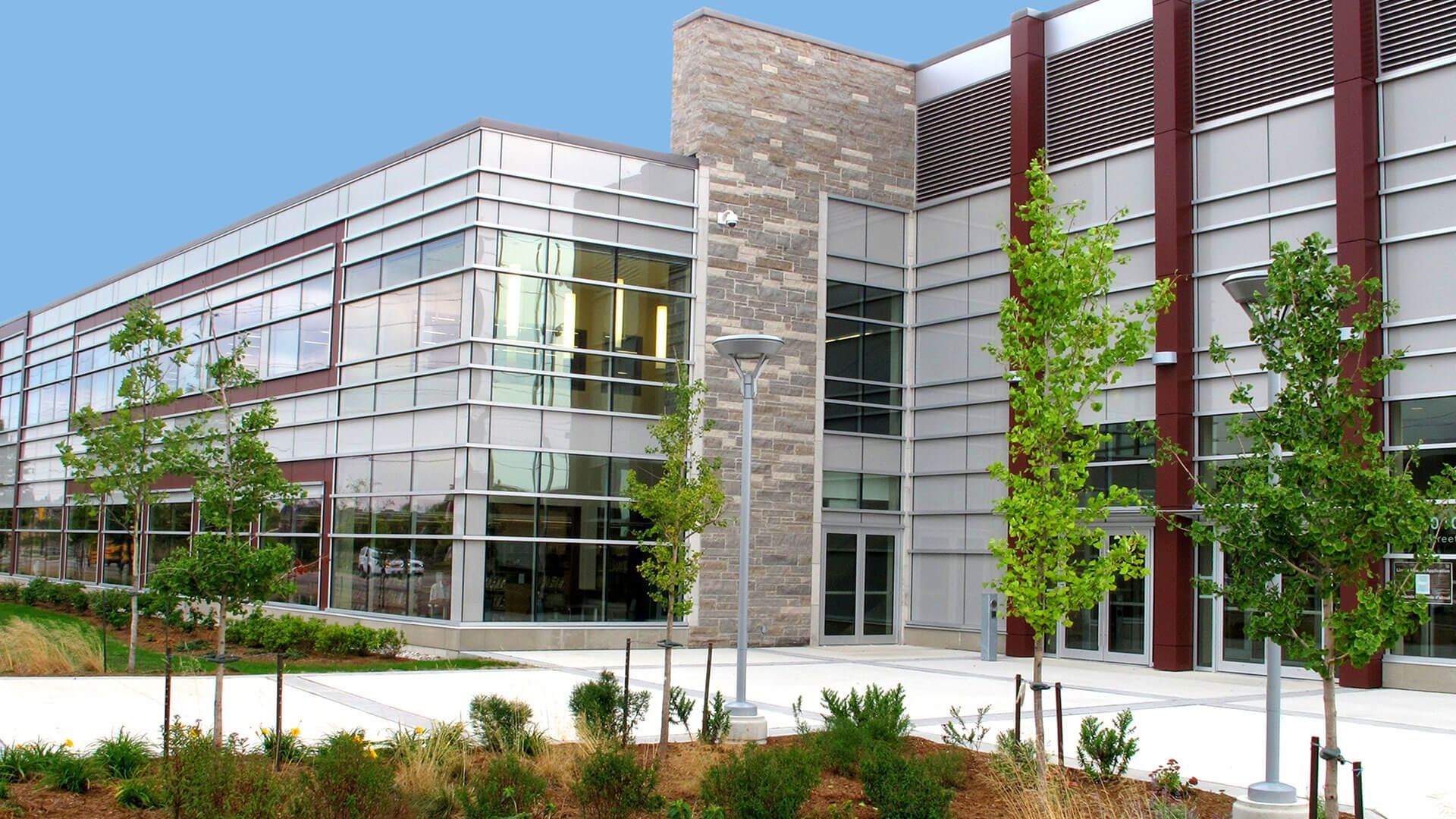 A large building with a lot of windows and trees in front of it