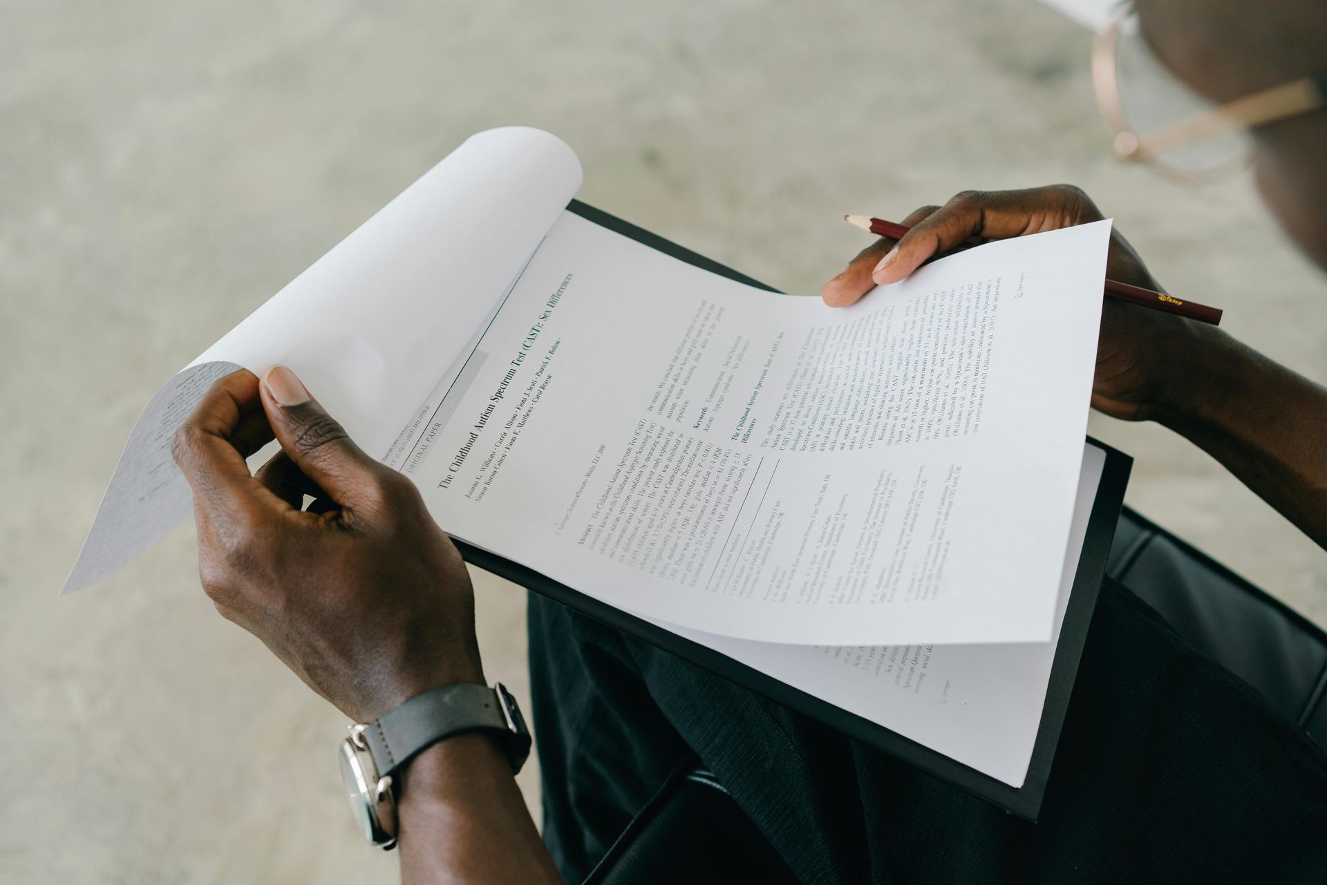 A person is holding a piece of paper and writing on it.