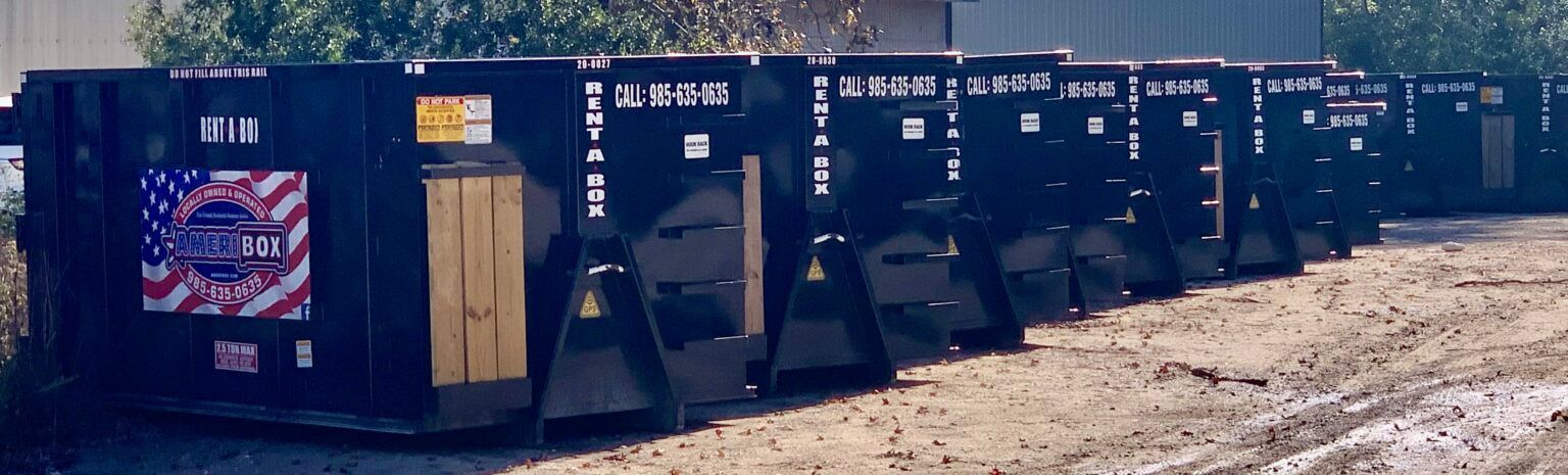 A picture of black Ameribox dumpsters lined up next to each other in a row.