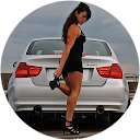 A woman in a black dress is standing in front of a white car.