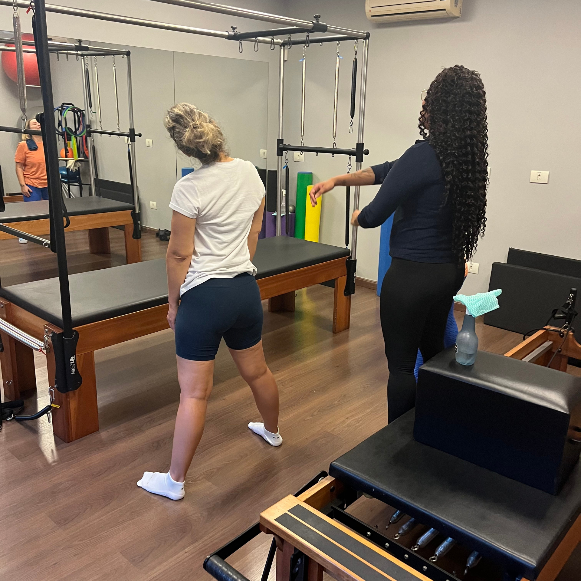 Duas mulheres estão fazendo pilates em uma academia