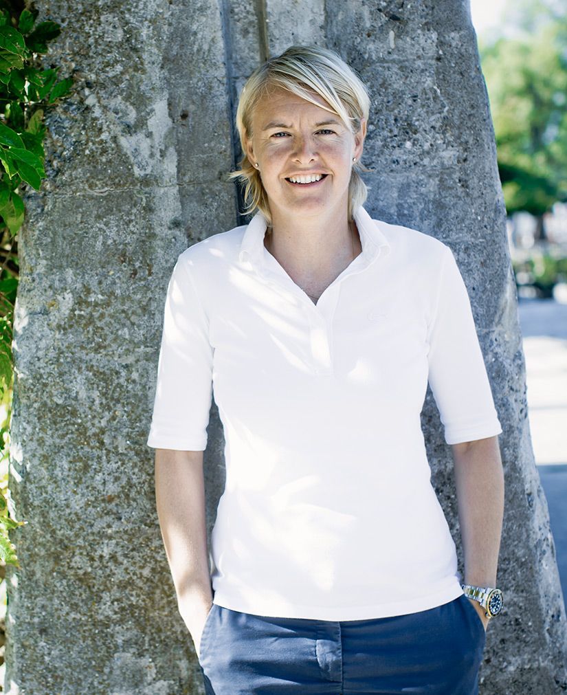 En kvinde lænet op ad et træ med hænderne i lommen