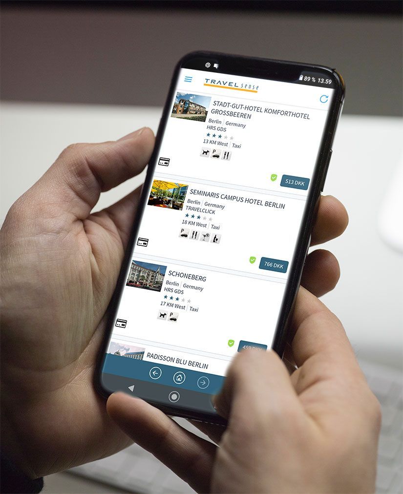 En person holder en mobiltelefon i hånden