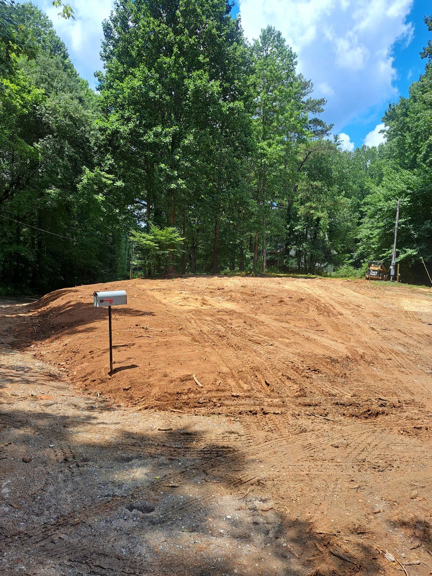 There is a mailbox in the middle of a dirt field.