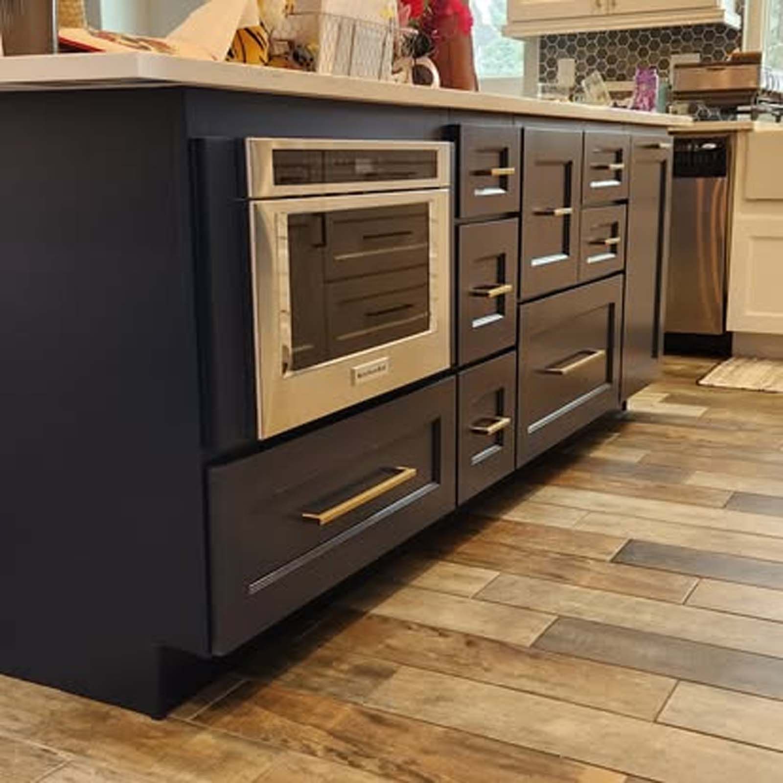 A kitchen with stainless steel appliances and wooden floors.