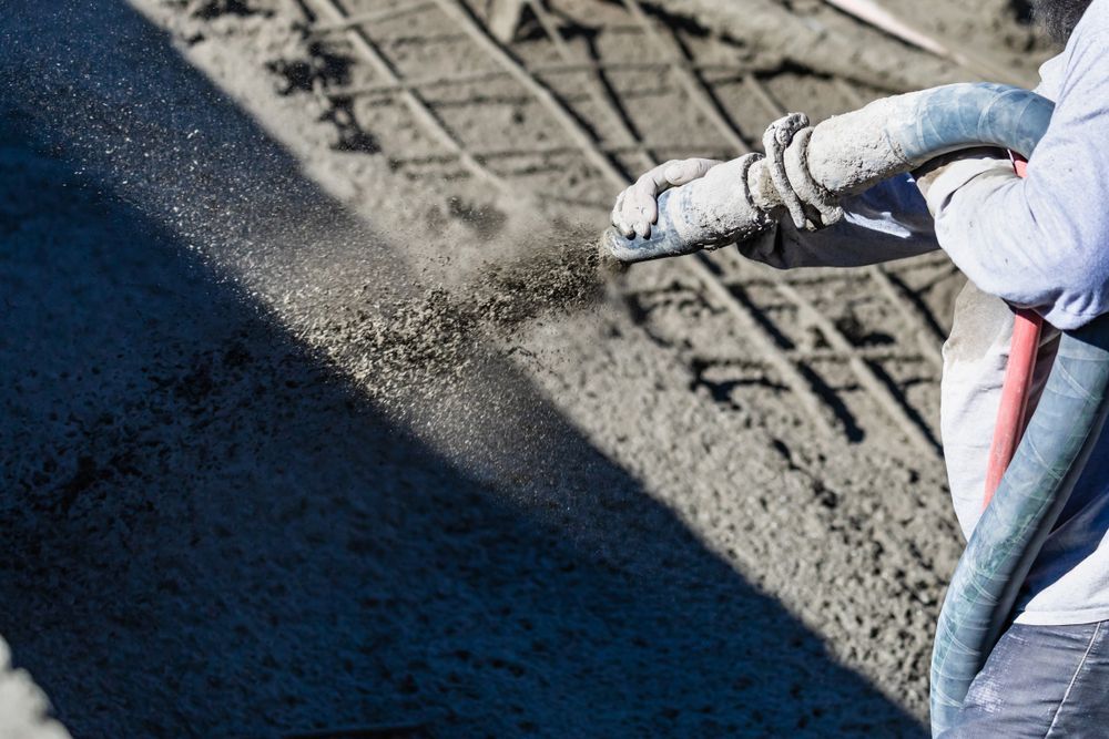 Person Spraying Concrete Onto Rebar, Construction Site — Atherton Tableland Concreting in Wongabel, QLD