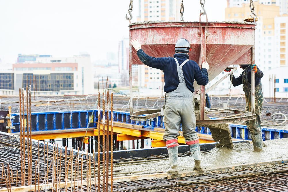 Construction Workers Pouring Concrete From a Crane-suspended Bucket — Atherton Tableland Concreting in Yungaburra, QLD
