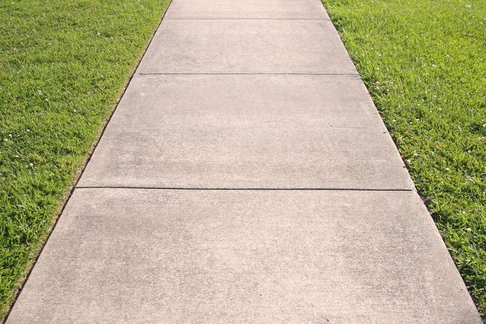 Concrete Sidewalk Flanked by Green Grass — Atherton Tableland Concreting in Yungaburra, QLD