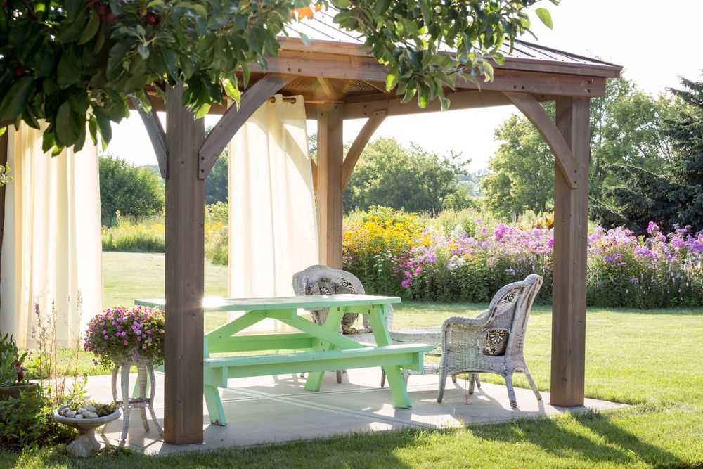 Wooden Gazebo With Green Picnic Table and Wicker Chair — Atherton Tableland Concreting in Yungaburra, QLD