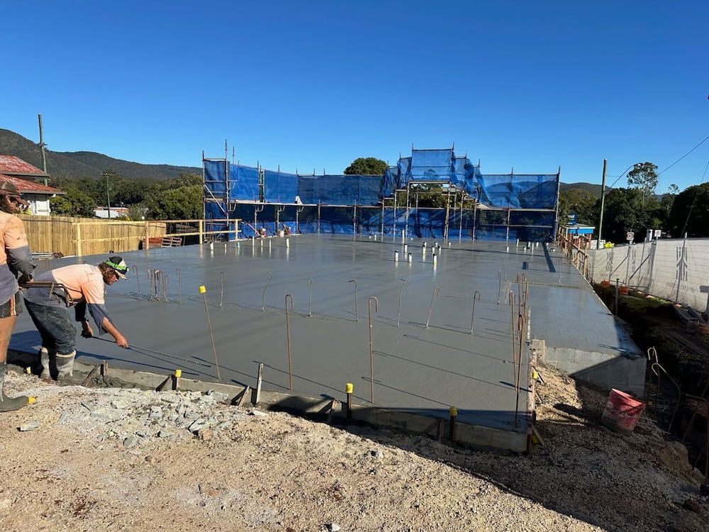 A Group of Construction Workers Are Working on a Concrete Floor — Atherton Tableland Concreting Pty Ltd in Yungaburra, QLD