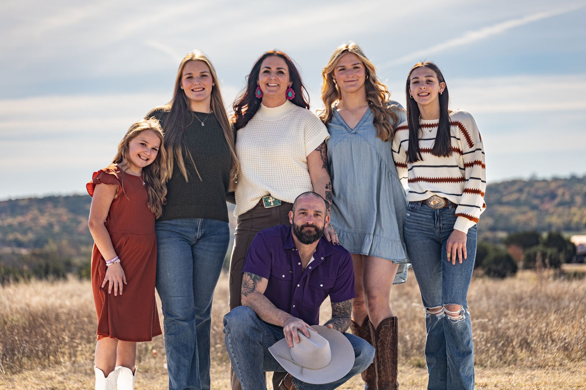 a woman is sitting on a bed using a laptop computer .