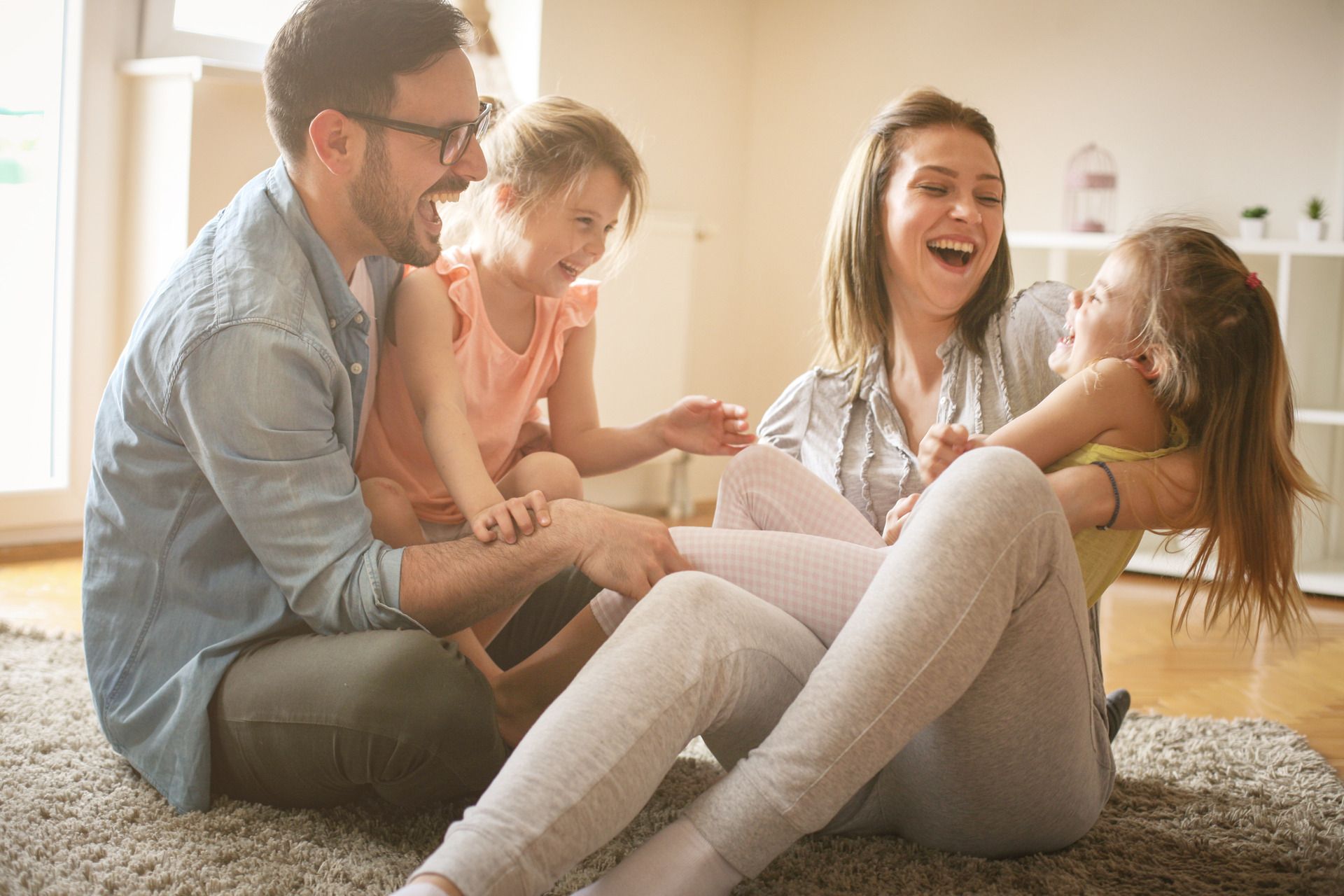 A family is sitting on a couch reading a book together.