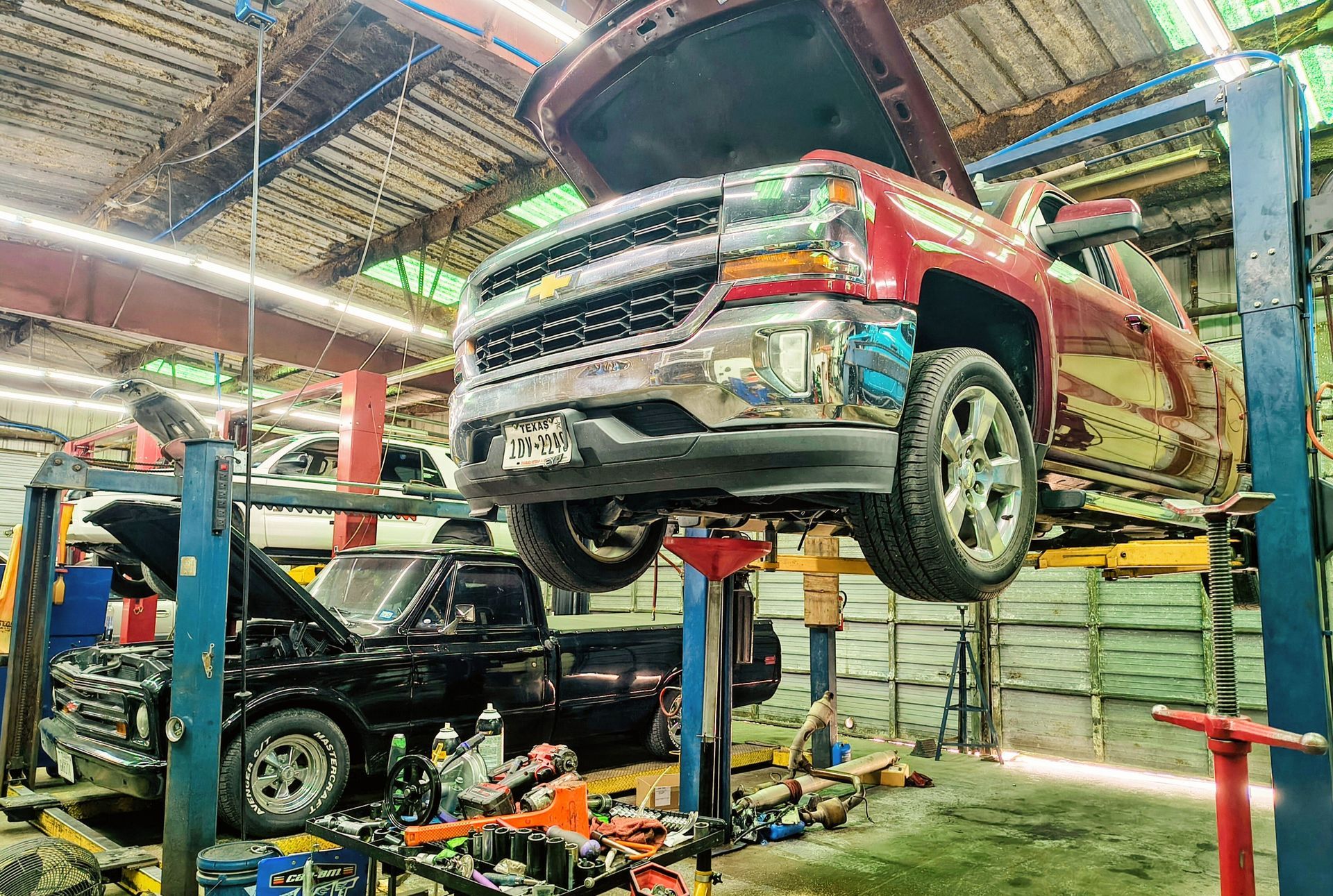Mechanic inspecting a car’s underside on a lift in a bright auto repair shop