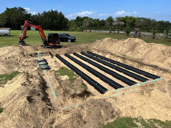 A septic system is being built in a dirt field.