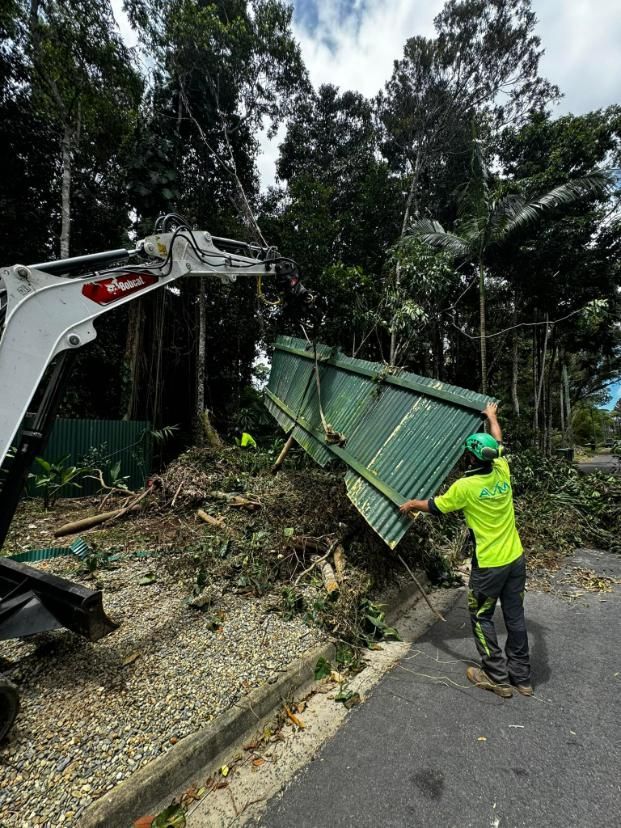 A Man in A Green Shirt Is Standing Next to A Large Piece of Metal — Advanced Vegetation Management in Stratford, QLD