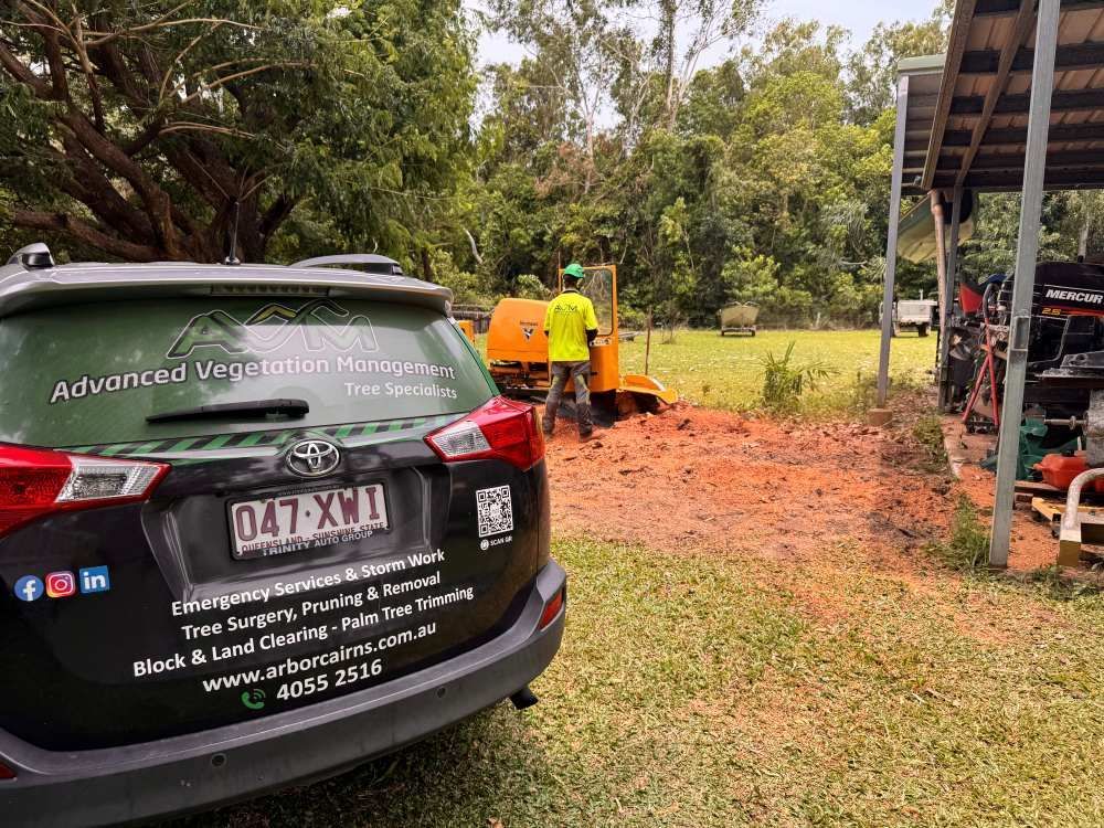 A Car is Parked in a Field Next to a Tree Stump Grinder — Advanced Vegetation Management in Stratford, QLD