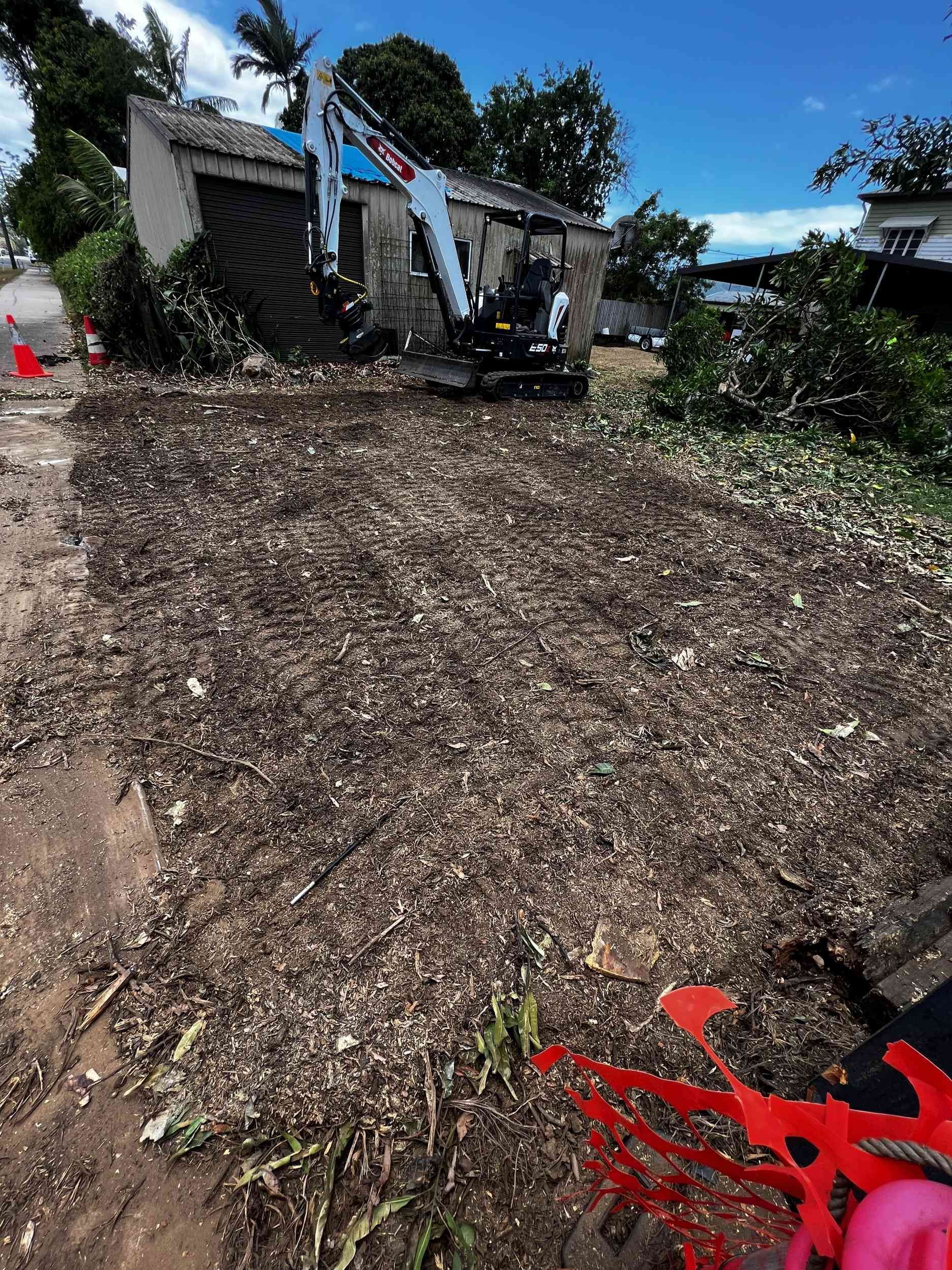A Large Pile of Wood Chips is Sitting in Front of a House — Advanced Vegetation Management in Innisfail, QLD