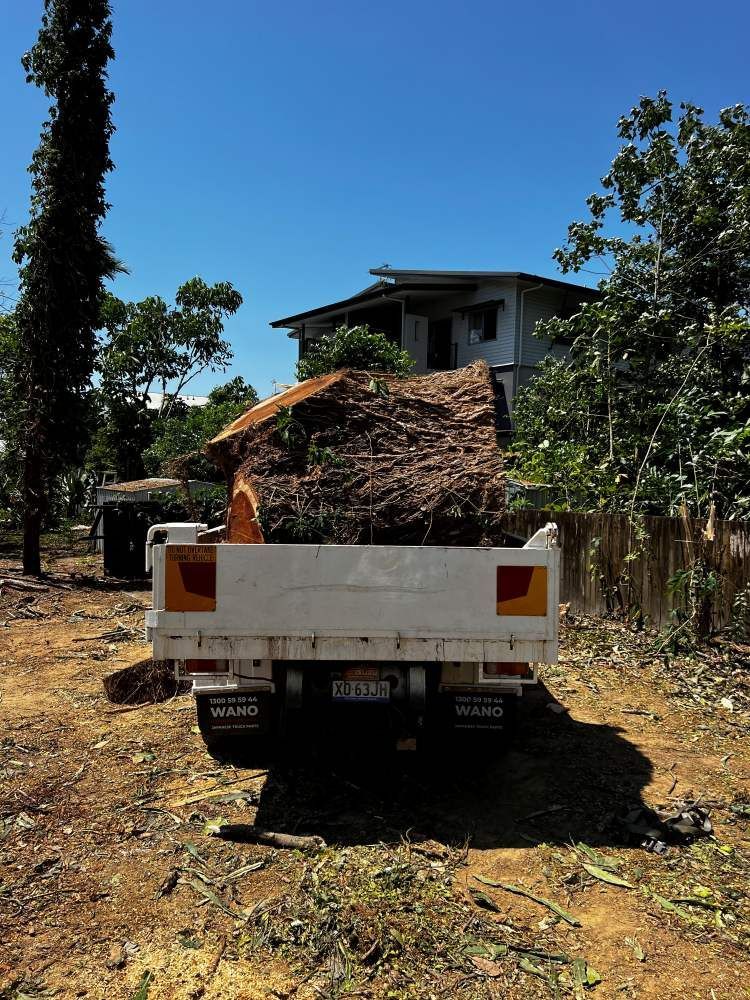 A White Truck is Parked in a Dirt Field in Front of a House — Advanced Vegetation Management in Yorkeys Knob, QLD