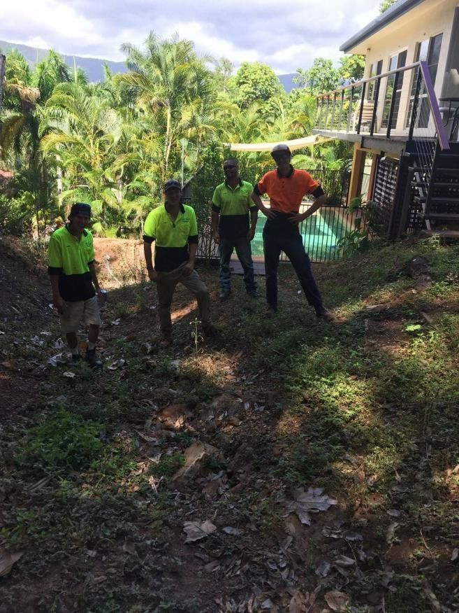 A Group of Men Are Standing on Top of A Hill in Front of A House — Advanced Vegetation Management in Stratford, QLD