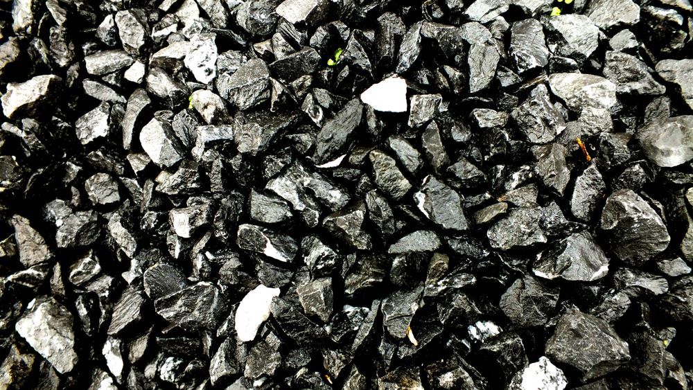 A Pile of Black Rocks is Sitting on the Ground — Dubbo Soils & Landscaping Supplies in Narromine, NSW