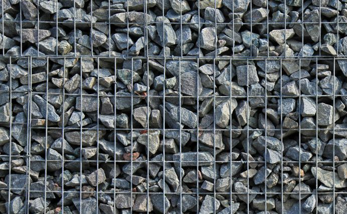 A Close Up of a Wire Fence Filled With Rocks — Dubbo Soils & Landscaping Supplies in Gilgandra, NSW