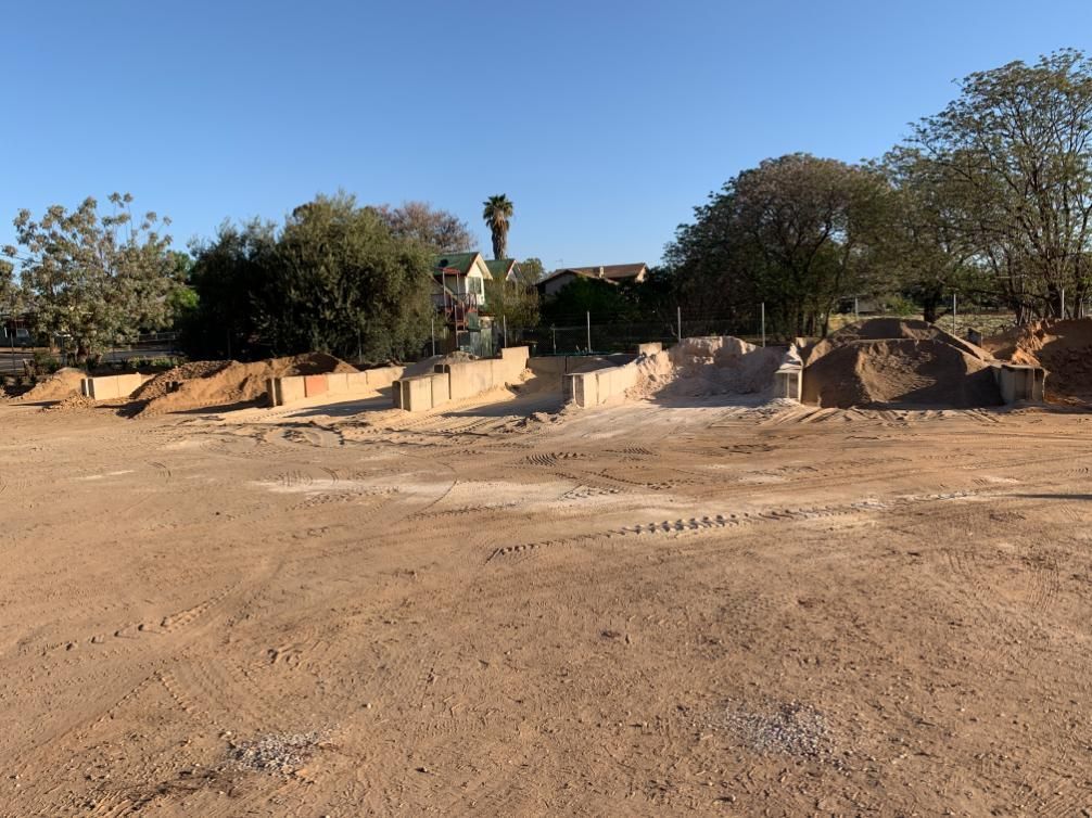 A Large Dirt Field With Trees in the Background — Dubbo Soils & Landscaping Supplies in Dubbo, NSW