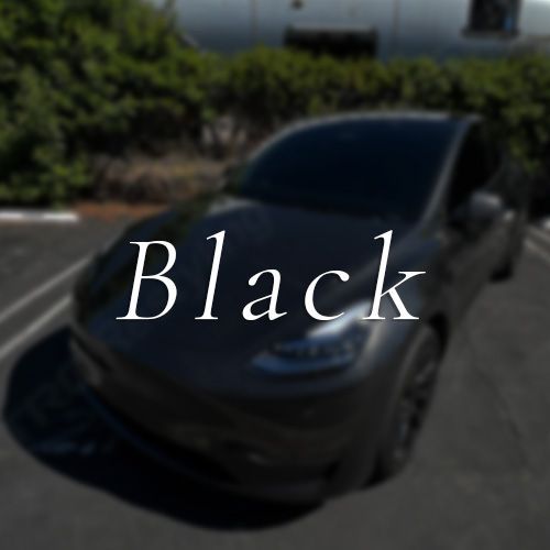 A black car is parked on the side of the road