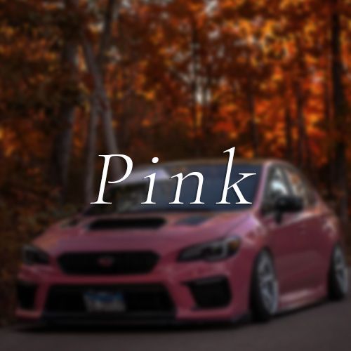 A pink car is parked on the side of the road