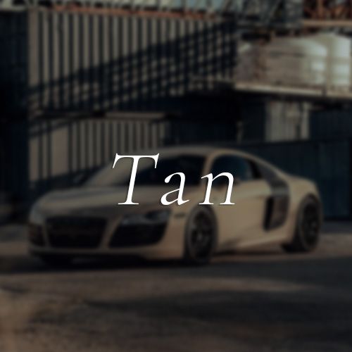 A tan sports car is parked in front of a building