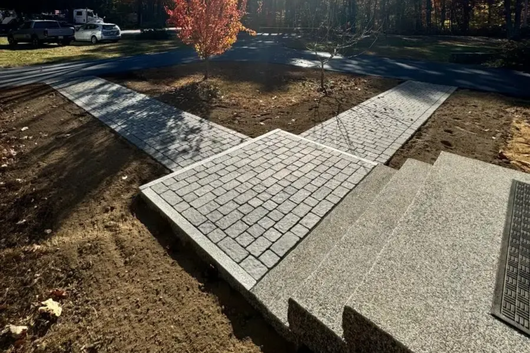 Stone walkway intersection with steps, constructed from pavers and gravel, leading to various directions.