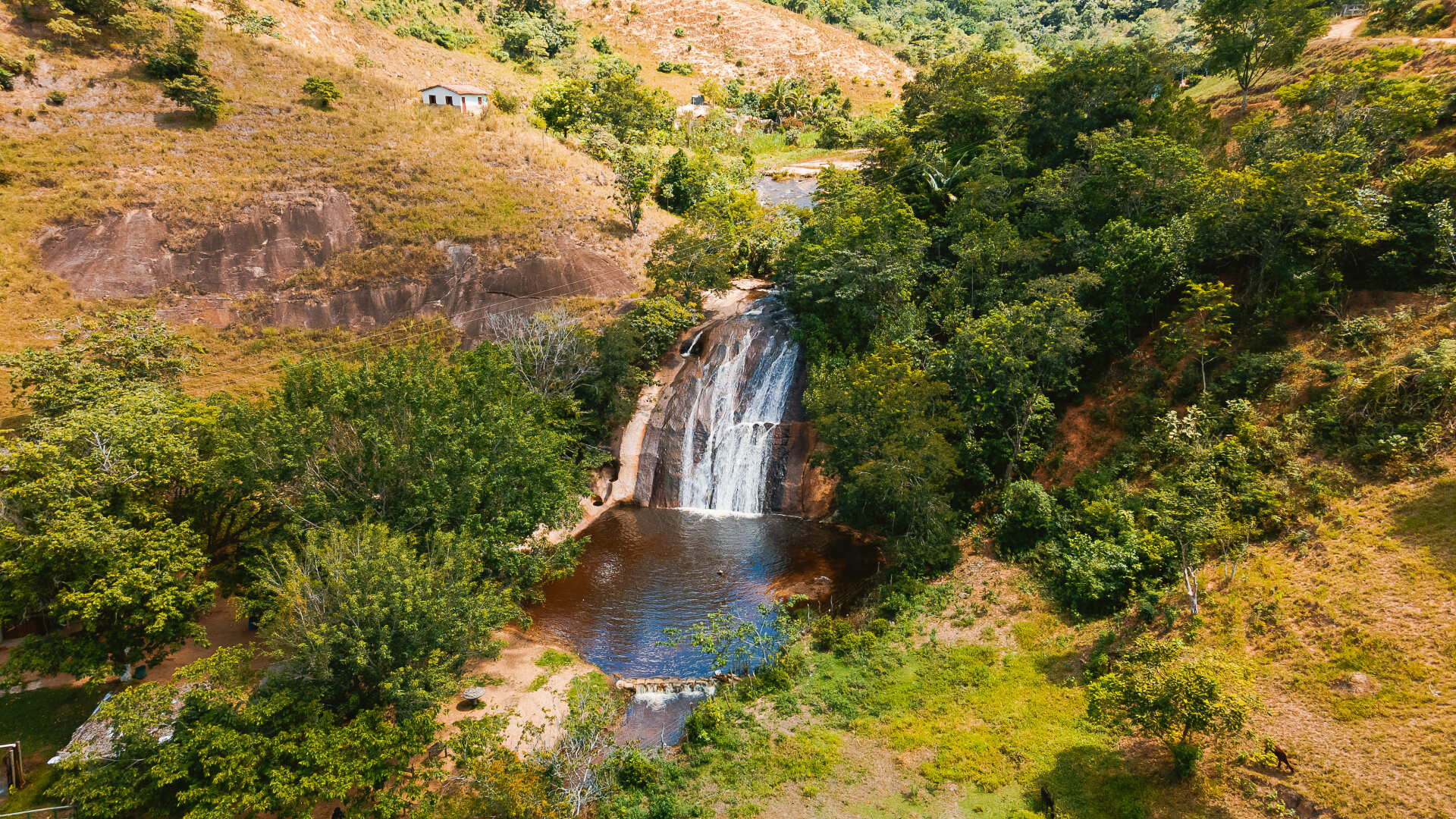 Uma vista aérea de uma cachoeira no meio de uma floresta verdejante.