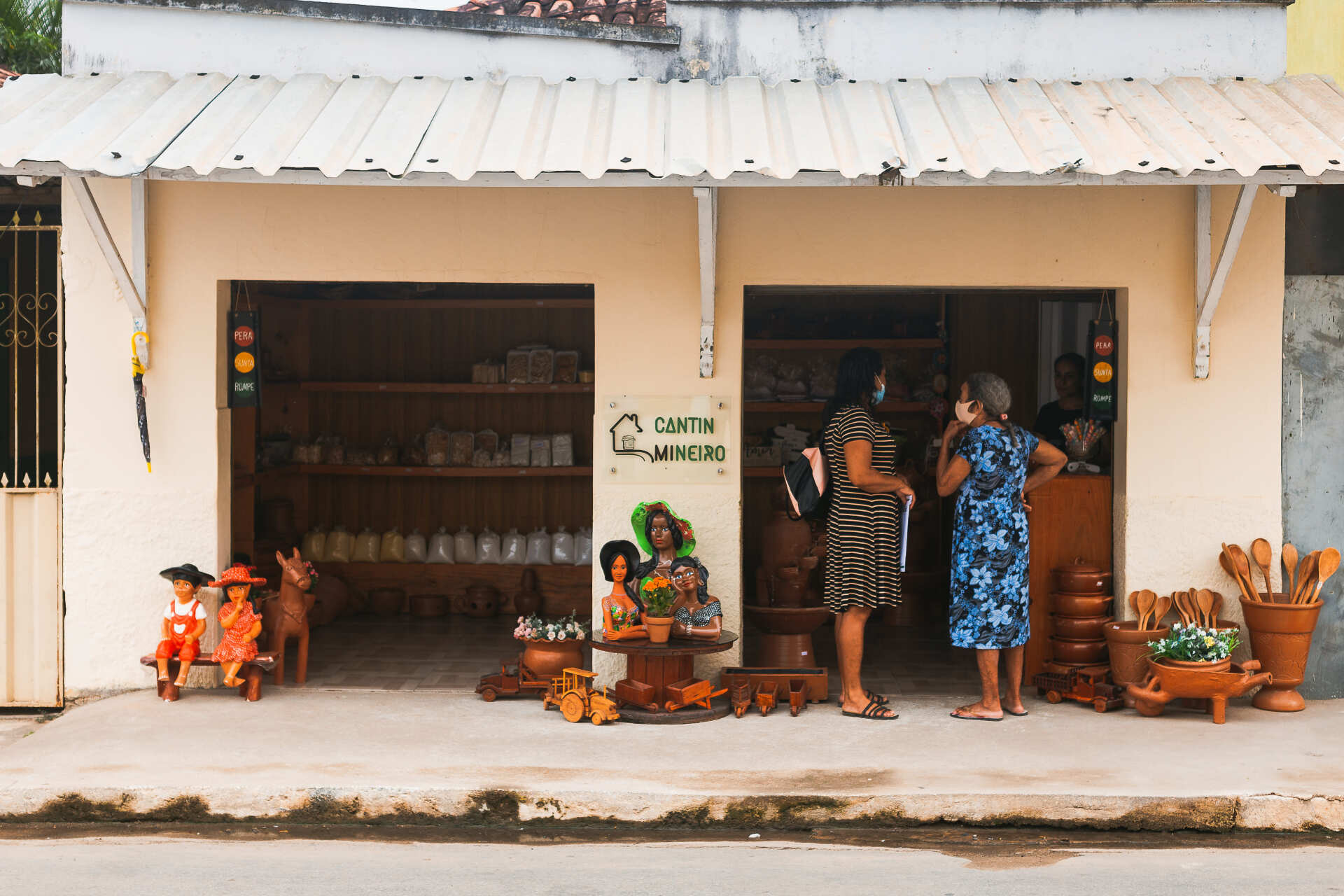 Um grupo de pessoas está do lado de fora de uma loja.
