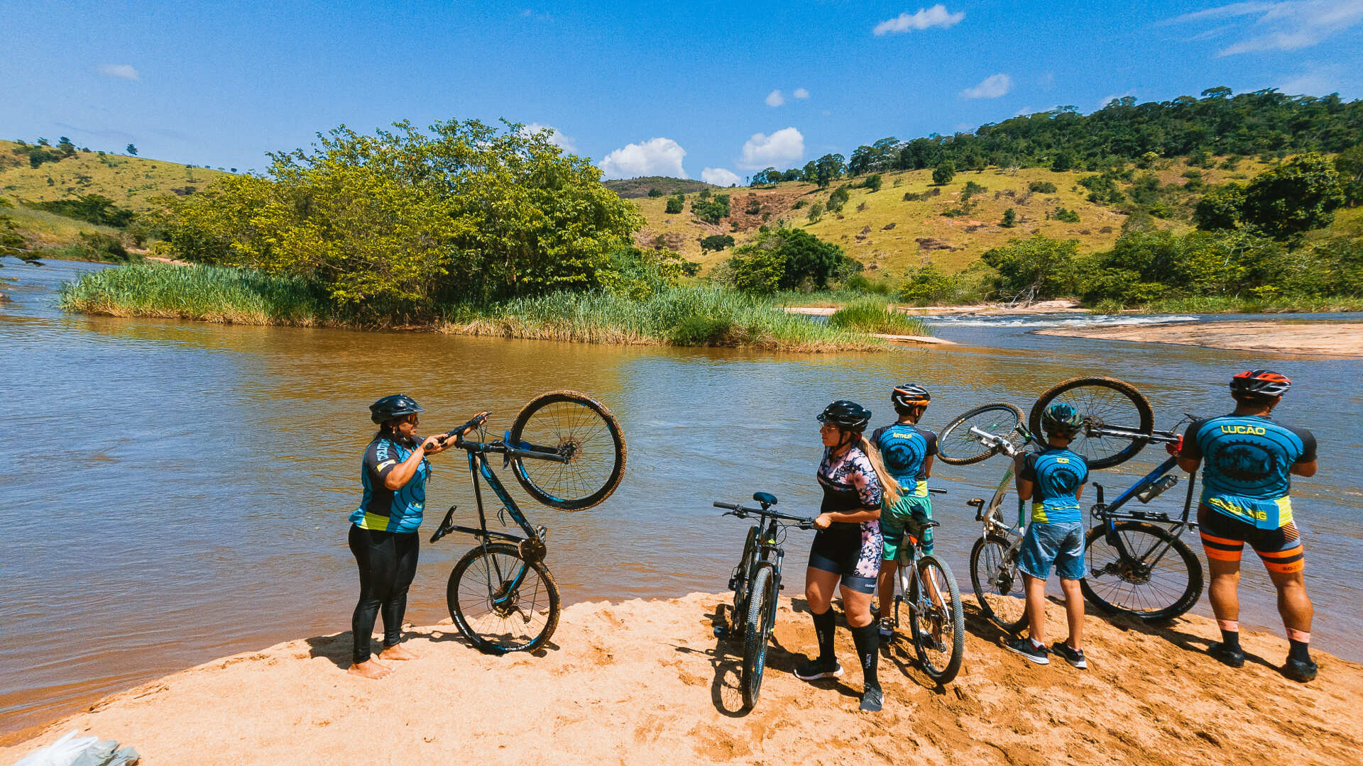 Um grupo de pessoas está na praia com suas bicicletas.
