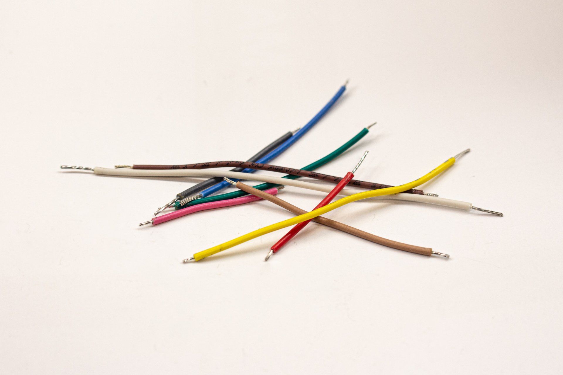 A bunch of different colored wires on a white surface