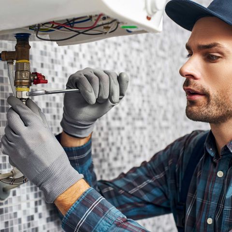 Plumber Fixing The Sink — Medford, OR — Cowboy Plumbing LLC