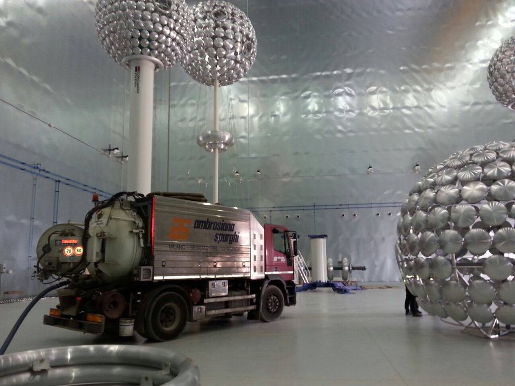 Un grande camion all'interno di una stanza con strutture sferiche argentate appese al soffitto e sul pavimento.