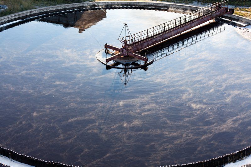 Vasca circolare per il trattamento delle acque reflue con braccio meccanico.