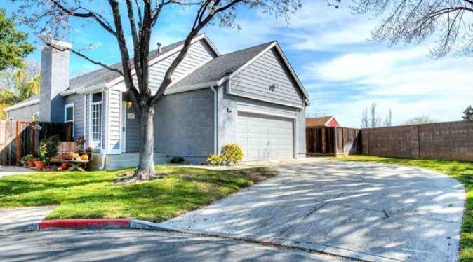 Gray house with a driveway on a sunny day, tree in front. Brentwood, CA Realtor Gina Bentley