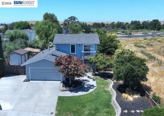 Blue two-story house with attached garage, green lawn, and landscaping. Sunny day. Single Family Home, Livermore, CA 94551 Sold By Realtor Gina Bentley