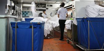 A woman in a white shirt is standing in a laundry room