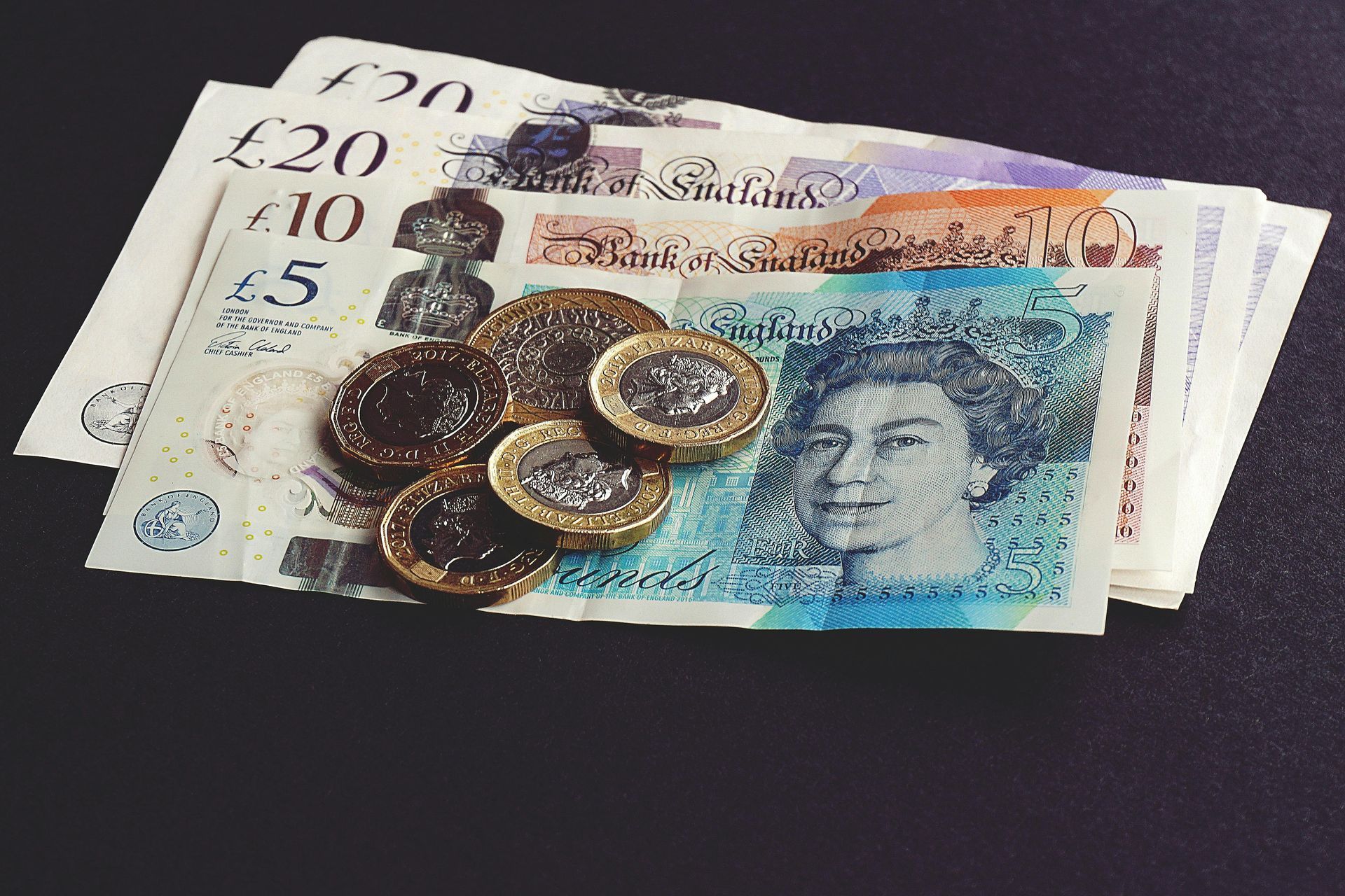 A stack of british pound notes and coins