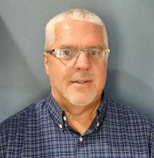 A grey-haired gentleman with plaid shirt