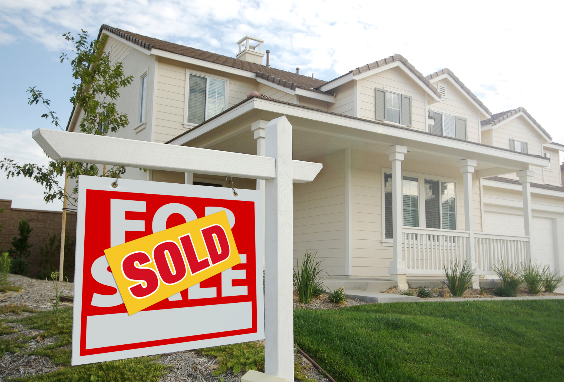 A house with a for sale sign in front of it