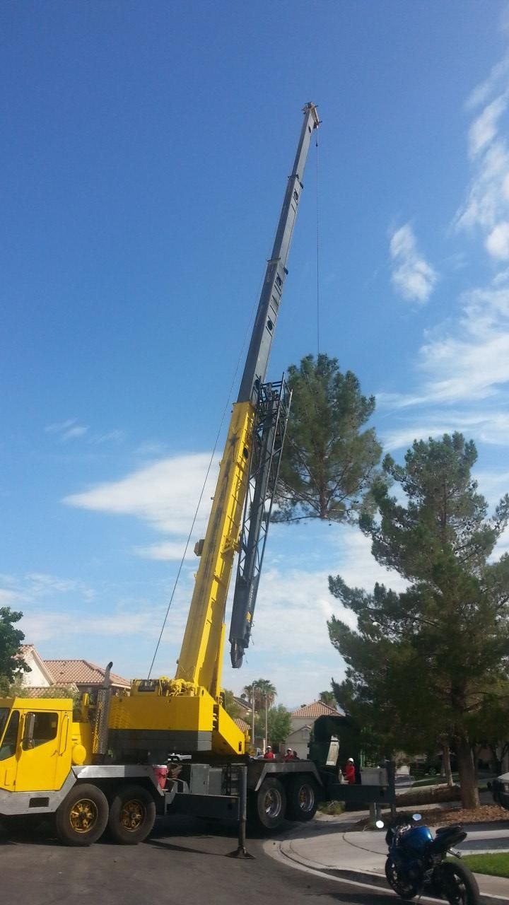 A large yellow crane is parked on the side of the road.