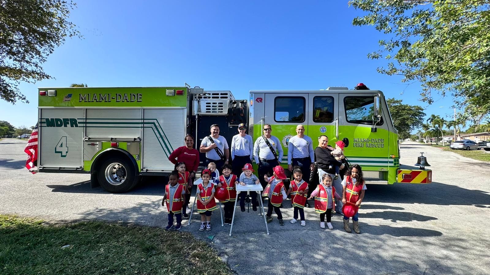 A group of children are standing in front of a fire truck.