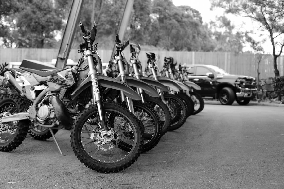 A row of dirt bikes are parked in a parking lot - Funeral Services in Upper Coomera, QLD