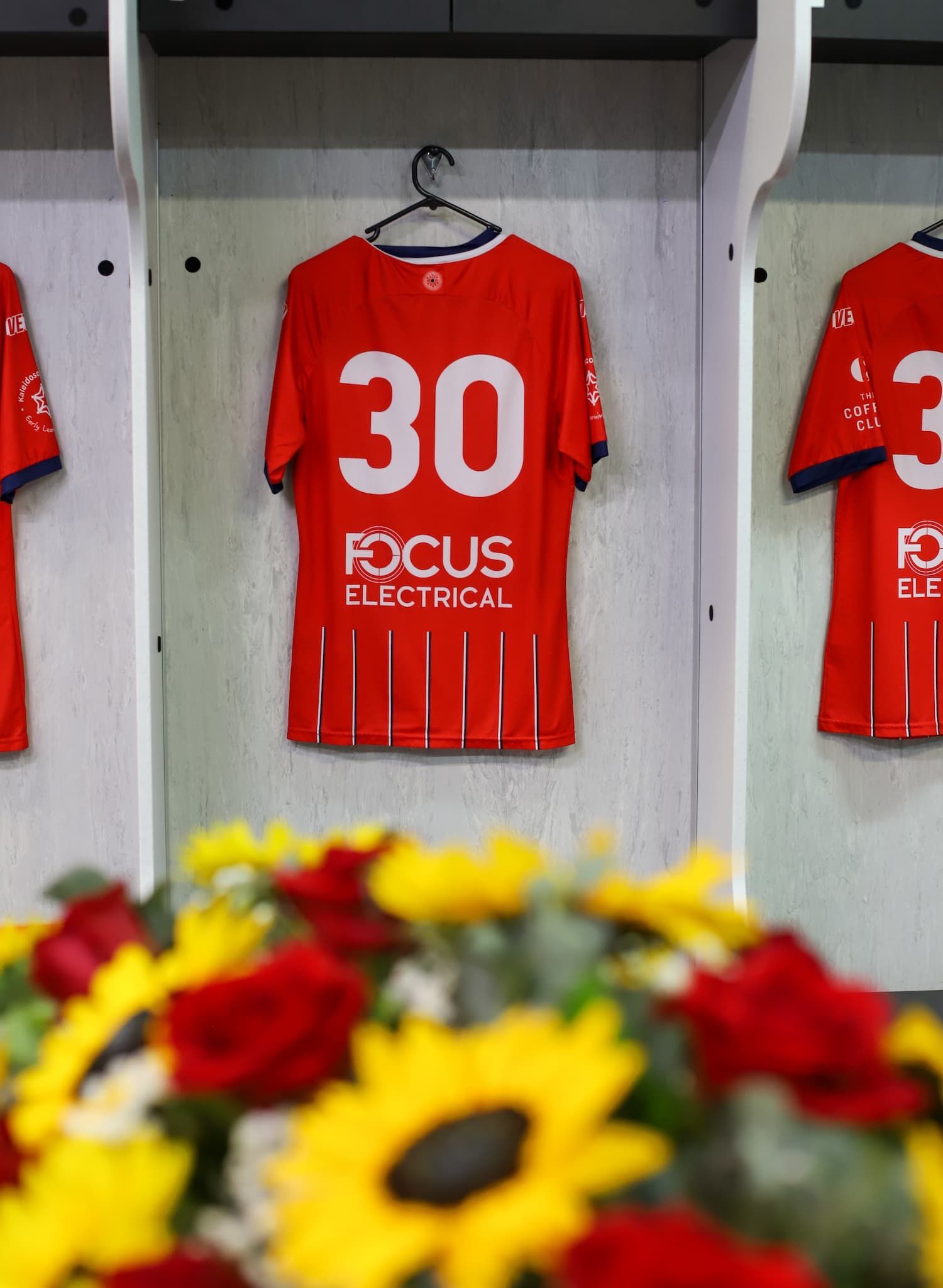 A red jersey with the number 30 on it hangs in a locker - Funeral Services in Upper Coomera, QLD