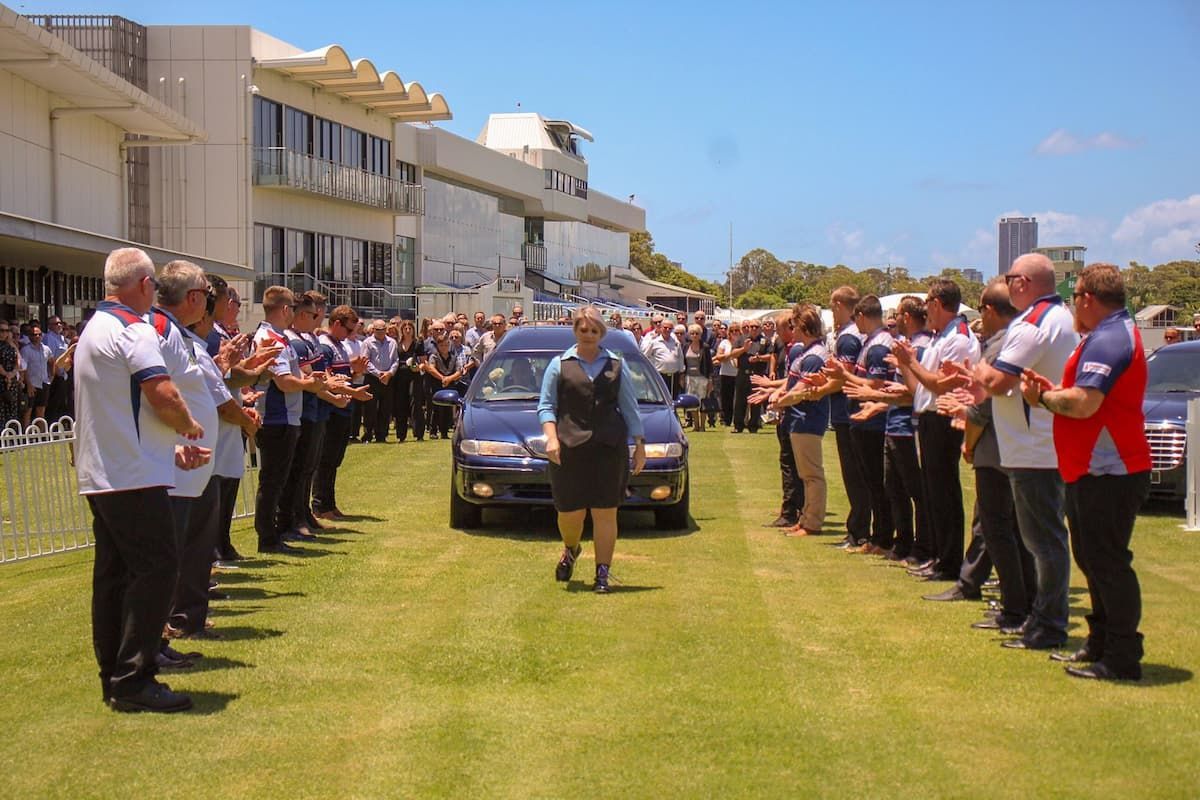 A woman walking in front of a funeral car - Funeral Services in Upper Coomera, QLD