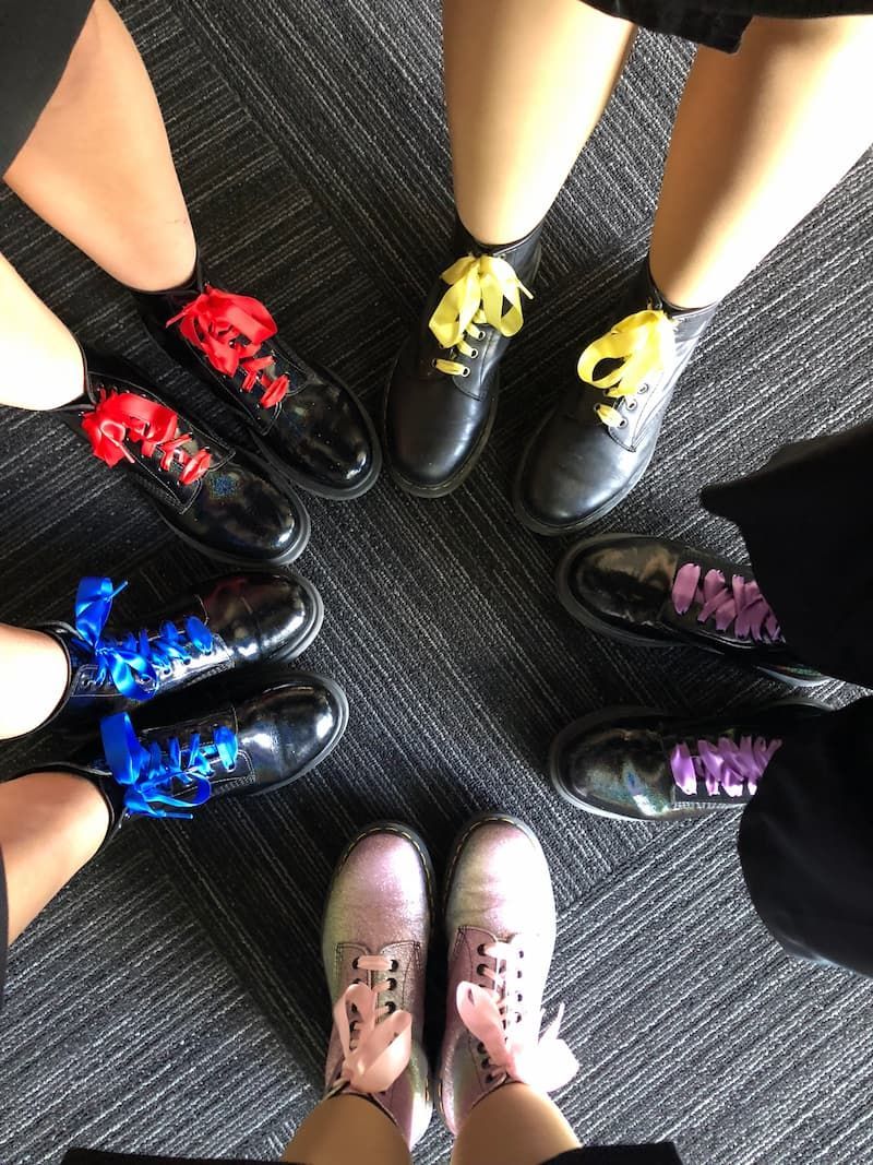 A group of people standing in a circle wearing different colored shoes - Funeral Services in Upper Coomera, QLD